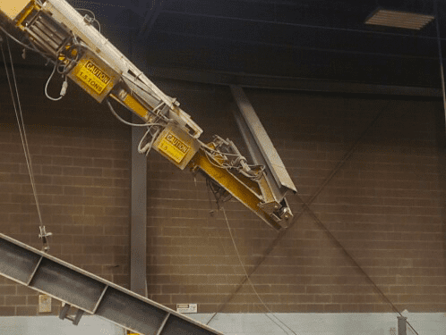 Catastrophic underhung overhead bridge crane runway fail, broken runway hanging loose from ceiling mount at metal finishing plant in central Indiana