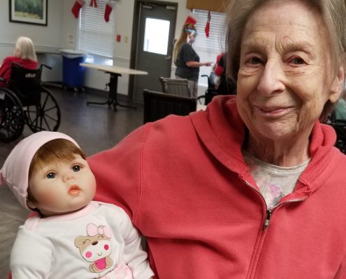 An elderly woman with a Lucys for Lynn doll