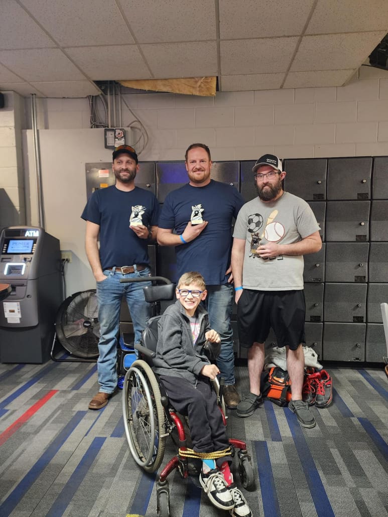 Ryan Wolfe of Service Crane Company with his family and Matt Riddle of Harriman Material Handling bowling at Blue River Bowl in Shelbyville, IN for Buddies Helping Buddies' first annual Strikes for a Cause fundraiser event sponsored by CraneWerks, Inc. of Morristown, IN.